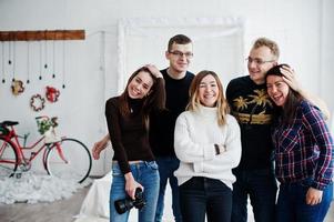 Group of five peoples, friends photographers and designers on studio shooting after hard work day. They happy and laughing. photo