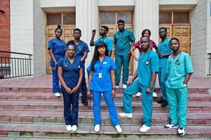 grupo de estudiantes de medicina africanos posaron al aire libre contra la puerta de la universidad. foto