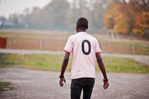 African american man in pink football sport t-shirt with zero number. photo