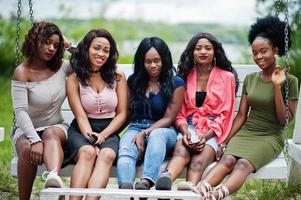 Group of five african american girls relaxing at beautiful swing. photo