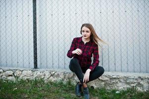 Young hipster girl in checkered shirt posed outdoor. photo