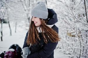 Two funny girls friends having fun at winter snowy day near snow covered trees. photo