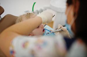 Little baby girl at dentist chair. Children dental. photo