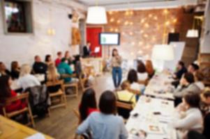 Master class and study concept. Abstract blurred photo of conference or seminar room with speaker on the stage.