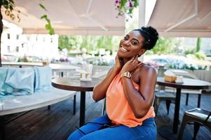 African american girl sitting on table of caffe and posed. photo