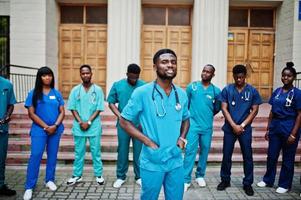 Group of african medical students posed outdoor against university door. photo