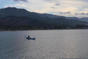 silueta de pescador en su barco foto