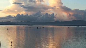 pescador en su barco al atardecer. barco de pescadores al atardecer foto