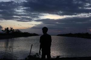 silhouette of a person on the lake photo