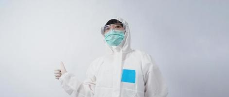 Doctor in PPE suit gesture make hand sign. Represent victory win over virus. photo