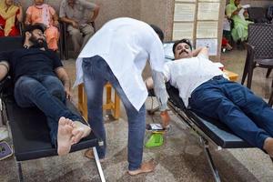 delhi, india, 19 de junio de 2022 - donante de sangre en el campamento de donación de sangre celebrado en el templo balaji, vivek vihar, delhi, india, imagen para el día mundial del donante de sangre el 14 de junio de cada año, campamento de donación de sangre en el templo foto