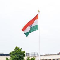 India flag flying high at Connaught Place with pride in blue sky, India flag fluttering, Indian Flag on Independence Day and Republic Day of India, tilt up shot, Waving Indian flag, Har Ghar Tiranga photo