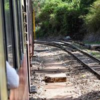 Toy Train moving on mountain slopes, beautiful view, one side mountain, one side valley moving on railway to the hill, among green natural forest. Toy train from Kalka to Shimla in India, Indian Train photo