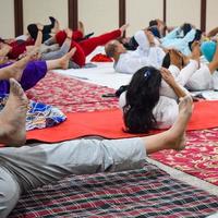 New Delhi, India, June 19 2022 -Group Yoga exercise session for people of different age groups in Balaji Temple, Vivek Vihar, International Yoga Day, Big group of adults attending yoga class in temple photo