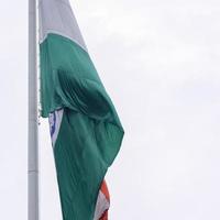 India flag flying high at Connaught Place with pride in blue sky, India flag fluttering, Indian Flag on Independence Day and Republic Day of India, tilt up shot, Waving Indian flag, Har Ghar Tiranga photo