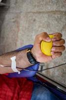 Blood donor at Blood donation camp held with a bouncy ball holding in hand at Balaji Temple, Vivek Vihar, Delhi, India, Image for World blood donor day on June 14 every year, Blood Donation Camp photo