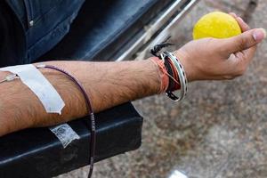 donante de sangre en el campamento de donación de sangre sostenido con una pelota hinchable en la mano en el templo balaji, vivek vihar, delhi, india, imagen para el día mundial del donante de sangre el 14 de junio de cada año, campamento de donación de sangre foto