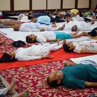 New Delhi, India, June 19 2022 -Group Yoga exercise session for people of different age groups in Balaji Temple, Vivek Vihar, International Yoga Day, Big group of adults attending yoga class in temple photo