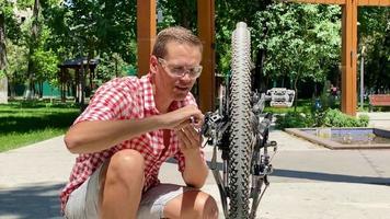 Male fixing bicycle in summer day