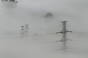 Electrical power lines and pylons emerging from the mist