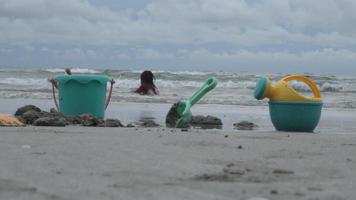 mignonnes petites soeurs jouant avec du sable sur la plage pendant les vacances d'été. enfants construisant un château de sable en mer. voyager avec des enfants video