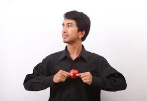 Young healthy man eating a red apple photo