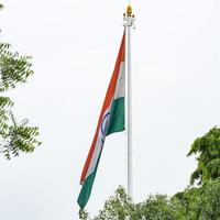 India flag flying high at Connaught Place with pride in blue sky, India flag fluttering, Indian Flag on Independence Day and Republic Day of India, tilt up shot, Waving Indian flag, Har Ghar Tiranga photo