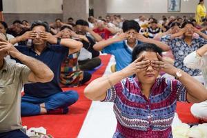 New Delhi, India, June 19 2022 -Group Yoga exercise session for people of different age groups in Balaji Temple, Vivek Vihar, International Yoga Day, Big group of adults attending yoga class in temple photo