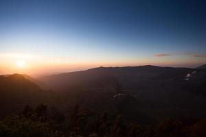 Foggy and volcano mountain during sunrise taken from Pinajagun II view point ,Indonesia photo