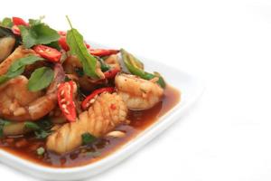 Spicy seafood fried served on white dish photo