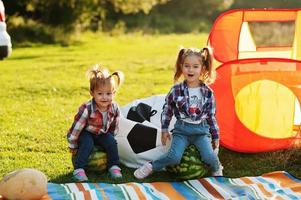 dos hermanitas lindas al aire libre en un picnic, usan camisa a cuadros. sentado en sandía. foto
