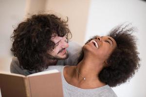 pareja multiétnica abrazándose frente a la chimenea foto