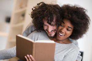 multiethnic couple hugging in front of fireplace photo