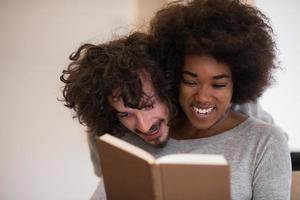 multiethnic couple hugging in front of fireplace photo