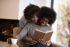 multiethnic couple hugging in front of fireplace photo