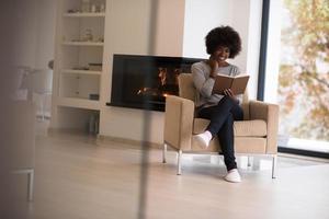 mujer negra en casa leyendo un libro foto