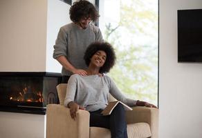 multiethnic couple hugging in front of fireplace photo