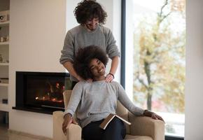 multiethnic couple hugging in front of fireplace photo