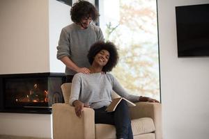 multiethnic couple hugging in front of fireplace photo