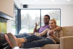 Young multiethnic couple  in front of fireplace photo