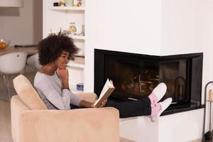 black woman at home reading book photo