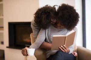 multiethnic couple hugging in front of fireplace photo