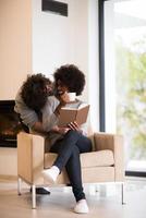 multiethnic couple hugging in front of fireplace photo