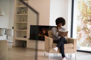 mujer negra en casa leyendo un libro foto