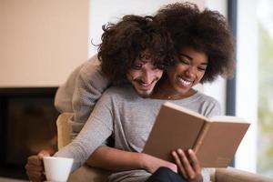 multiethnic couple hugging in front of fireplace photo