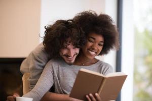 multiethnic couple hugging in front of fireplace photo