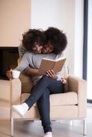 multiethnic couple hugging in front of fireplace photo