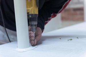 repairman working with drilling machine photo