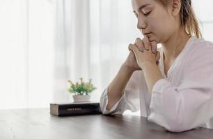 Hand of woman while praying for christian religion, Casual woman praying with a cross, Religion concept. photo