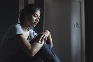 Depressed woman on the bed, stress, suicidal thoughts, human trafficking photo